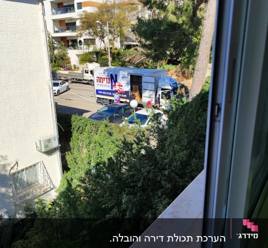 משאית הובלה חונה ברחוב ליד בניין מגורים